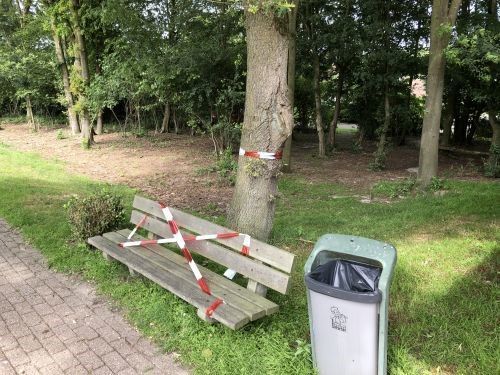 Een dag nadat de vakantieganger zijn aanvaring met het rupsennest had gemeld, werd het bewuste bankje bij de eikenboom omwikkeld met rood-wit lint.