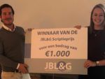 De COO van JBL&G Frederik Lieben overhandigt de € 1.000,- cheque aan de winnaar van de JBL&G Scriptieprijs Laura Kroese.