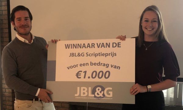De COO van JBL&G Frederik Lieben overhandigt de JBL&G Scriptieprijs aan de winnaar Laura Kroese.