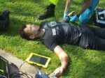 Slachtoffer wordt door een ambulancebroeder onderzocht nadat hij door losse tegels van zijn scooter is gekatapulteerd.