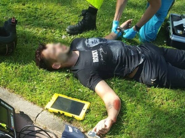 Slachtoffer wordt door een ambulancebroeder onderzocht nadat hij door losse tegels van zijn scooter is gekatapulteerd.