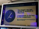 Een bord in een lijnbus waarop staat dat er in de bus een gordelplicht geldt.